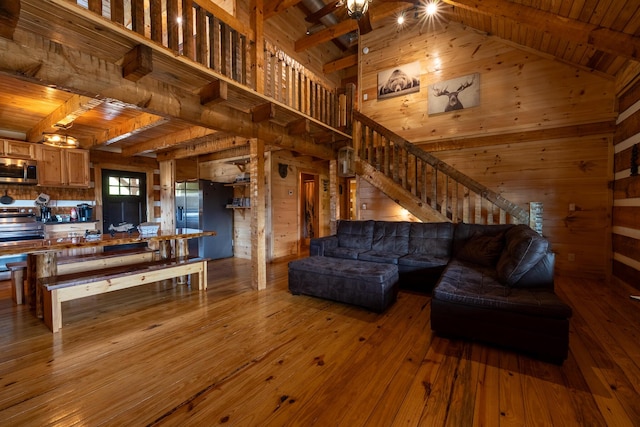 living room with hardwood / wood-style floors, high vaulted ceiling, ceiling fan, beamed ceiling, and wood ceiling