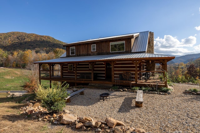 rear view of house featuring a deck with mountain view and an outdoor fire pit