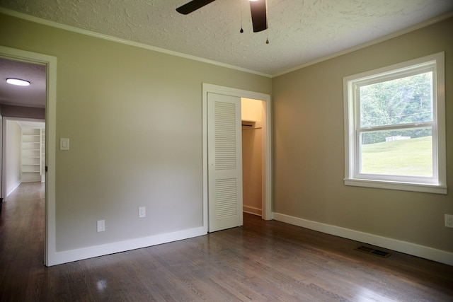 unfurnished bedroom with ceiling fan, wood-type flooring, a textured ceiling, a closet, and ornamental molding