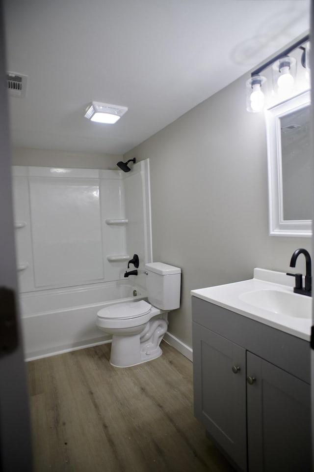 full bathroom with washtub / shower combination, wood-type flooring, vanity, and toilet