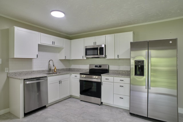 kitchen featuring decorative backsplash, light stone counters, stainless steel appliances, sink, and white cabinetry