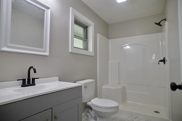 bathroom featuring vanity, toilet, a shower, and a textured ceiling