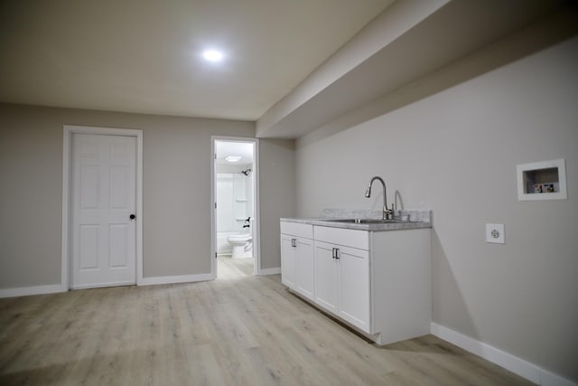 washroom featuring washer hookup, electric dryer hookup, sink, and light hardwood / wood-style flooring