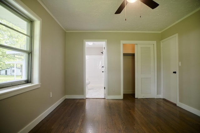 unfurnished bedroom featuring ensuite bathroom, crown molding, ceiling fan, and dark hardwood / wood-style floors