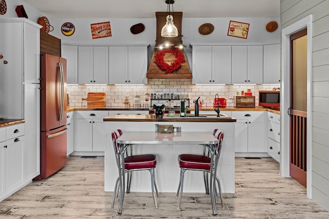 2545 Amanda Ln, Sevierville, TN 37876 - kitchen featuring freestanding refrigerator, light wood-type flooring, a kitchen island, and decorative backsplash