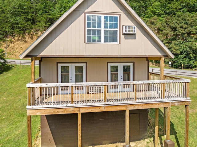 back of property with french doors, a deck, and a lawn