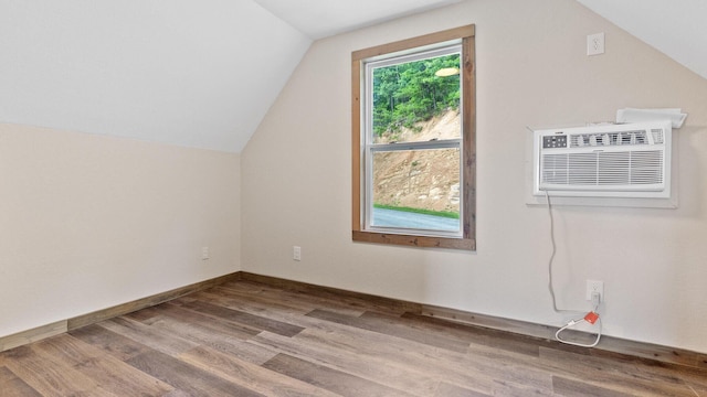 bonus room featuring hardwood / wood-style flooring, vaulted ceiling, and an AC wall unit