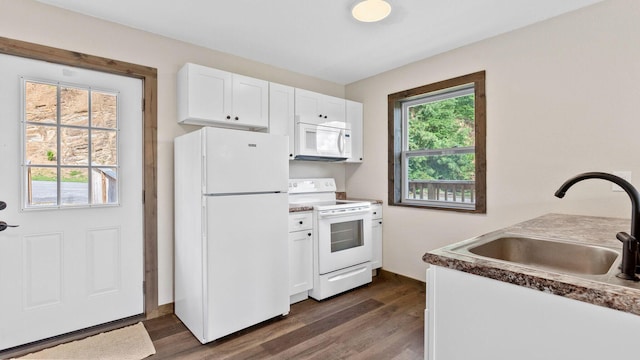 kitchen with white appliances, dark hardwood / wood-style floors, sink, and white cabinets