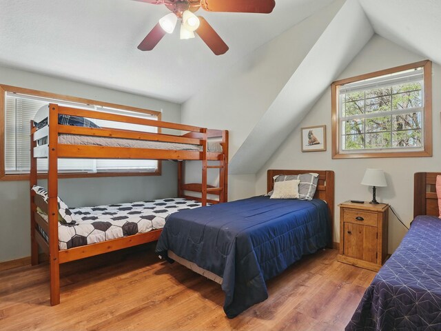 bedroom with vaulted ceiling, baseboards, ceiling fan, and wood finished floors