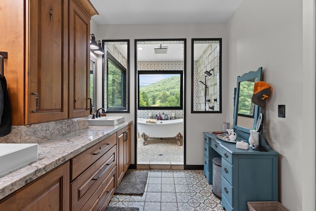 bathroom featuring tile patterned floors, a bathtub, vanity, and a healthy amount of sunlight