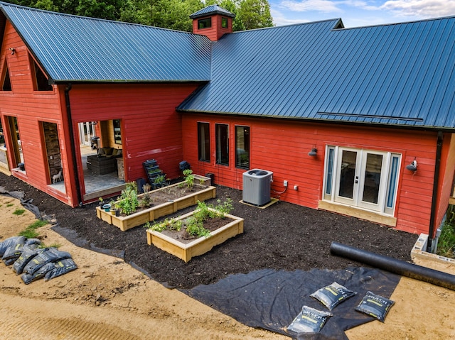 rear view of house with central air condition unit and french doors