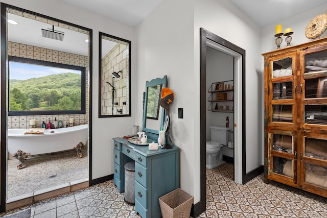 bathroom featuring a washtub and toilet