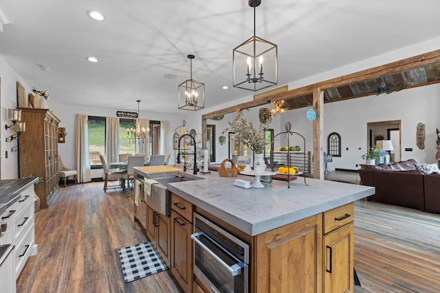 kitchen featuring pendant lighting, sink, a center island with sink, and white cabinets