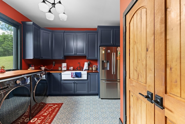 clothes washing area with cabinets, washing machine and dryer, and sink