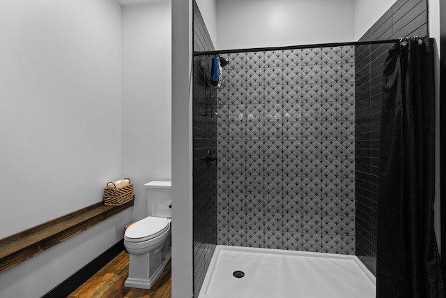 bathroom featuring toilet, hardwood / wood-style floors, and walk in shower