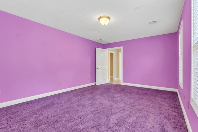 carpeted empty room featuring visible vents and baseboards