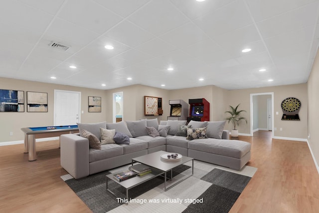 living area with visible vents, baseboards, and wood finished floors