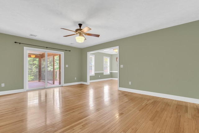 spare room with visible vents, light wood-style flooring, baseboards, and ceiling fan