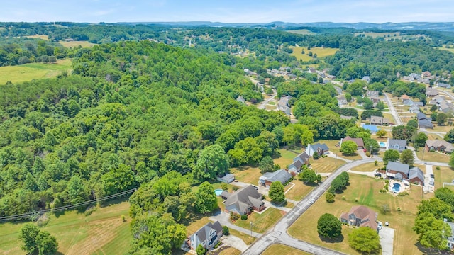 drone / aerial view featuring a residential view and a wooded view