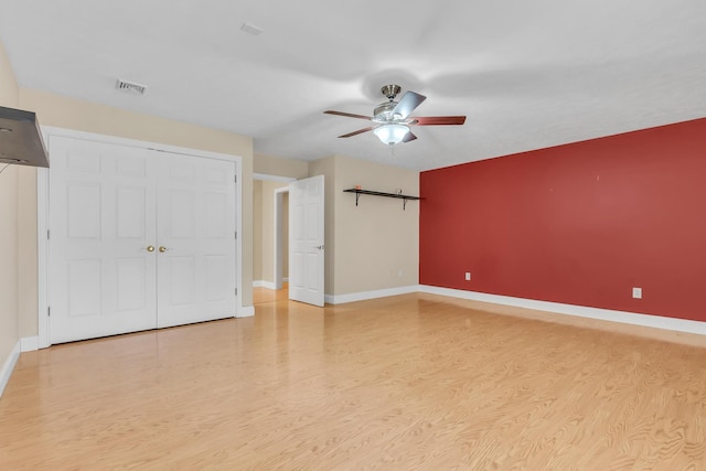 interior space with a ceiling fan, baseboards, and light wood finished floors