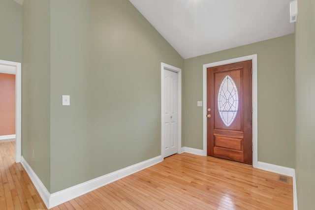 entryway featuring vaulted ceiling, baseboards, visible vents, and light wood finished floors