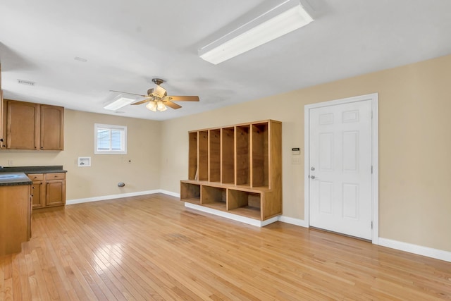 unfurnished living room with light wood finished floors, visible vents, and baseboards