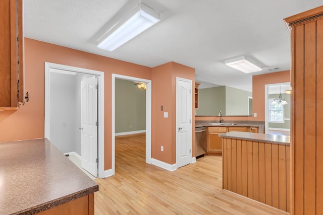 kitchen with visible vents, baseboards, stainless steel dishwasher, light wood-style floors, and a sink