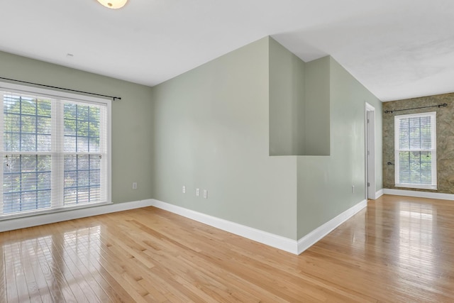 spare room featuring light wood-style flooring and baseboards