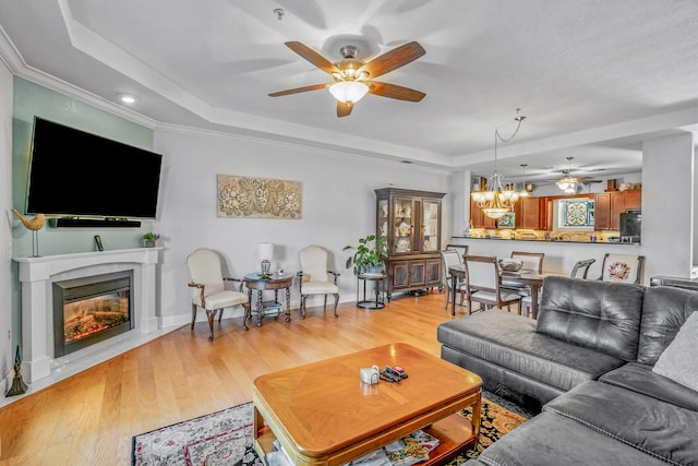 314 Sandpiper Ln, Bean Station, TN 37708 - living room featuring ceiling fan, a tray ceiling, light wood-style floors, a chandelier, and ornamental molding