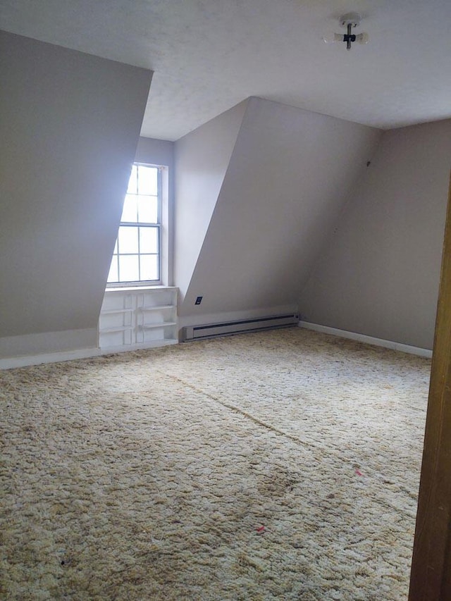 additional living space featuring lofted ceiling, a baseboard heating unit, and carpet