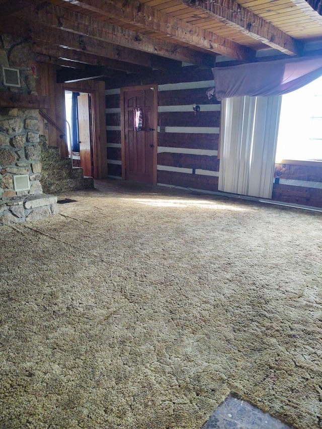 interior space with carpet flooring, beam ceiling, and wood ceiling