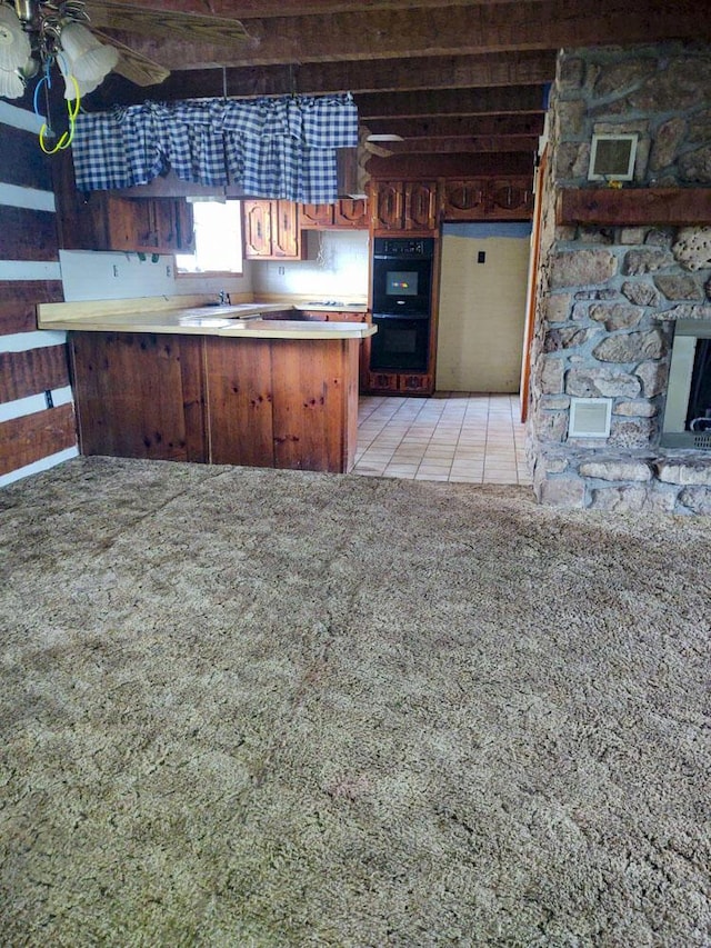 kitchen with double oven, fridge, light carpet, and kitchen peninsula