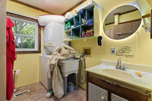 bathroom featuring tile patterned floors, vanity, and stacked washer / drying machine