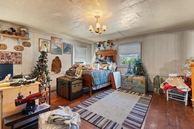 bedroom with a notable chandelier and dark hardwood / wood-style flooring