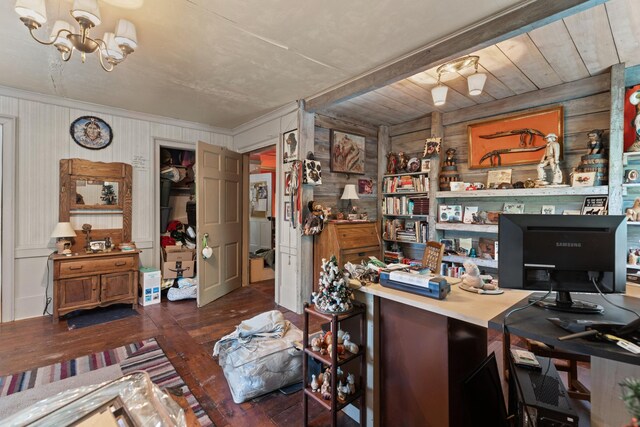 home office with a chandelier, dark wood-type flooring, and wood walls