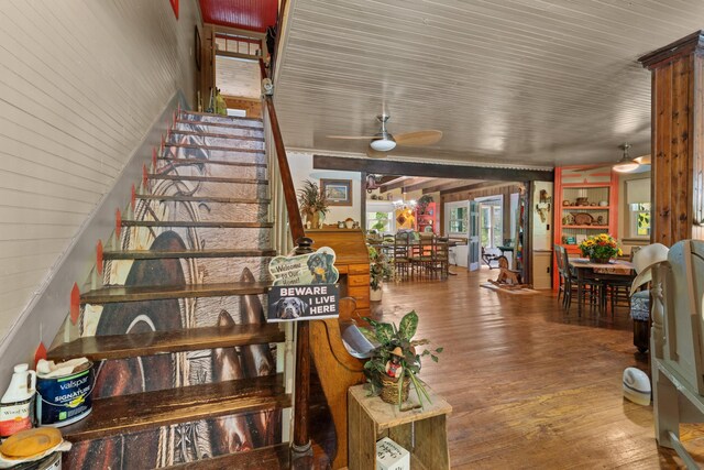 stairs featuring hardwood / wood-style flooring and ceiling fan