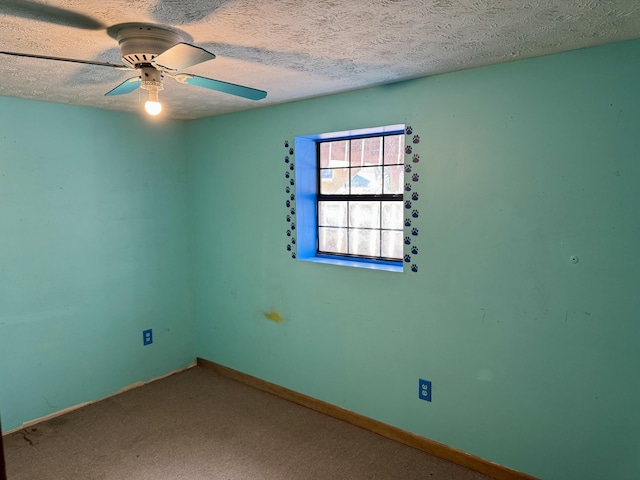 carpeted spare room featuring ceiling fan, a textured ceiling, and baseboards