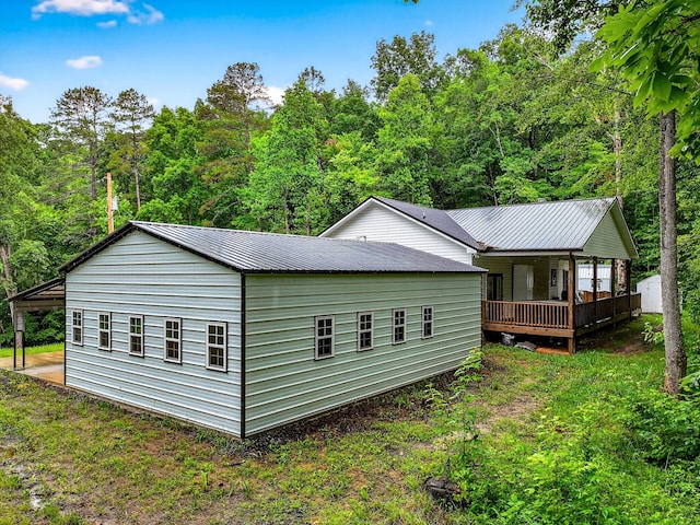 718 Mullins Dr, Sneedville, TN 37869 - view of property exterior featuring a metal roof, a view of trees, and a wooden deck