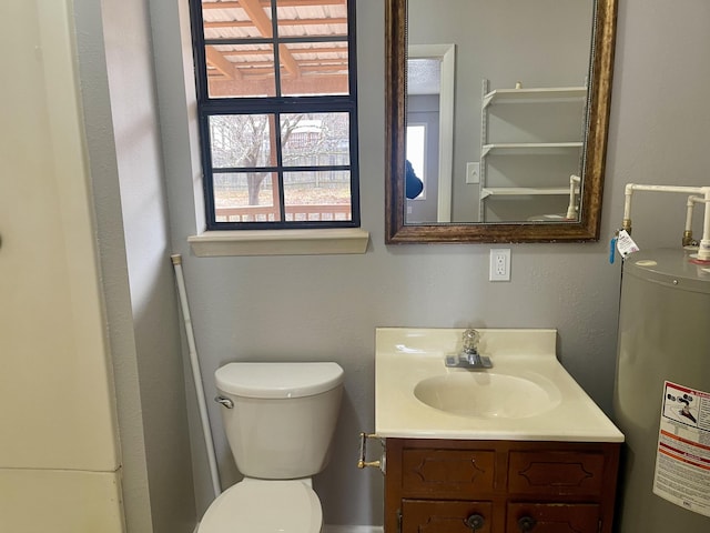 bathroom with vanity, toilet, and gas water heater