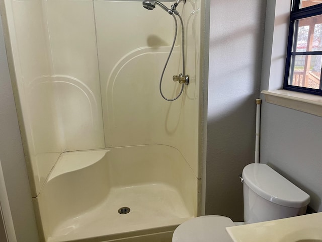 bathroom featuring toilet and walk in shower