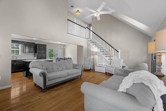 1790 Butterfly Ct, Whitesburg, TN 37891 - living area with high vaulted ceiling, light wood-type flooring, a ceiling fan, stairs, and a chandelier