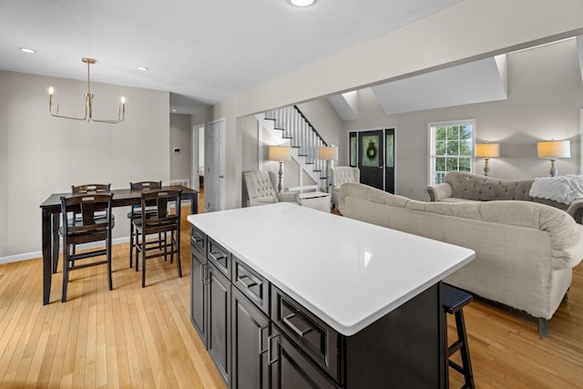 1790 Butterfly Ct, Whitesburg, TN 37891 - kitchen featuring a chandelier, a center island, light wood-type flooring, dark cabinets, and open floor plan