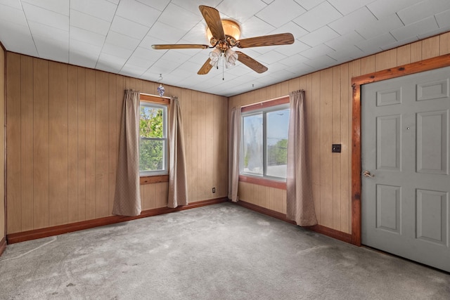 1900 Mountain View Ave, Kingsport, TN 37664 - spare room featuring baseboards, a ceiling fan, wooden walls, and carpet flooring
