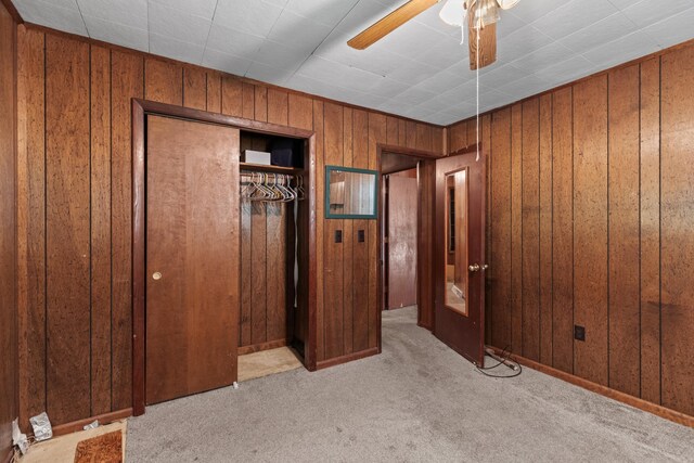 1900 Mountain View Ave, Kingsport, TN 37664 - unfurnished bedroom featuring a closet, a ceiling fan, carpet flooring, and wood walls