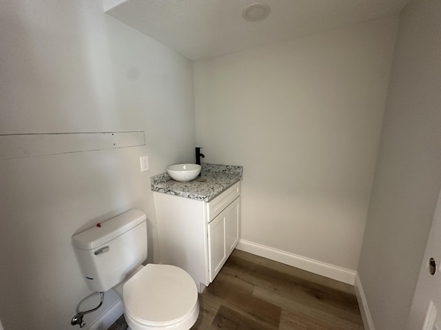 bathroom featuring hardwood / wood-style floors, vanity, and toilet