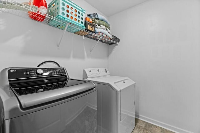 laundry room with laundry area, washing machine and dryer, and baseboards