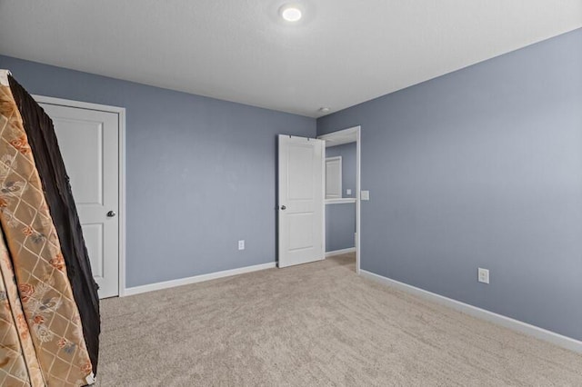 unfurnished bedroom with carpet floors and baseboards