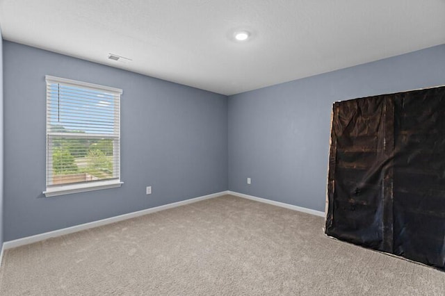 empty room with baseboards, carpet, and visible vents