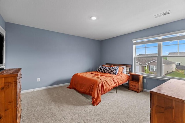 bedroom featuring light colored carpet, baseboards, and visible vents