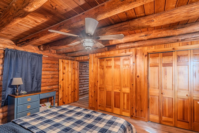 484 Buttermilk Rd, Blountville, TN 37617 - unfurnished bedroom with a wood ceiling with exposed beams, log walls, multiple closets, and light wood-style floors